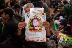 An Iranian pilgrim shows the image of his relative, martyred during the war between Iraq and Iran, the war imposed, as the Iranians usually call it.